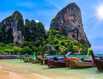 Longtail boats on the emerald water of Railay Beach